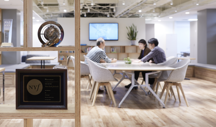 社内でのディレクター、デザイナー、コピーライターのミーティングのシーン