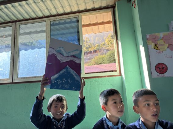 自作の絵を掲げるラムチェ村の子供